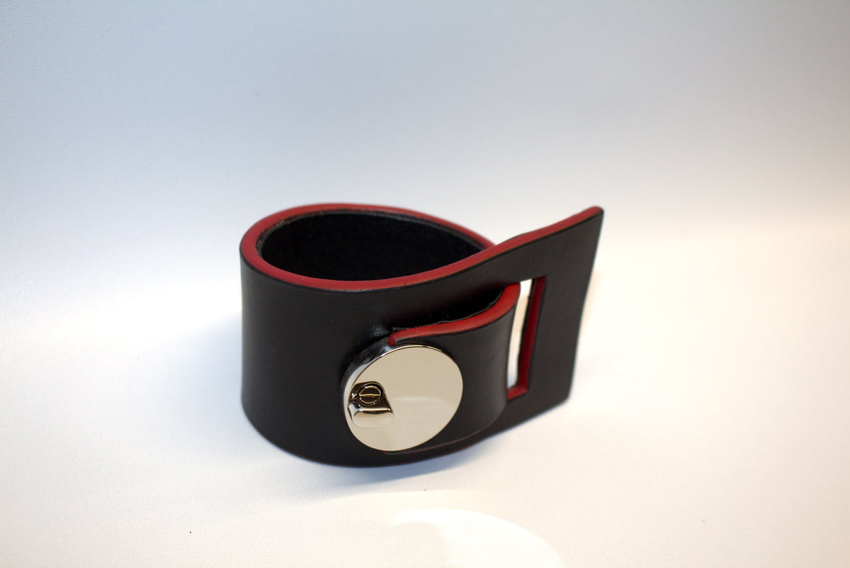 Distinct: black leather cuff with red edges and round lock